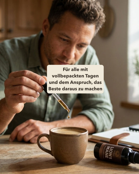 Mann am Tisch mit offener Agenda daneben. Er Tropft Lion's Mane in eine Tasse. Textoverlay 'Für alle mit vollbepackten Tagen und dem Anspruch, das Beste daraus zu machen.'