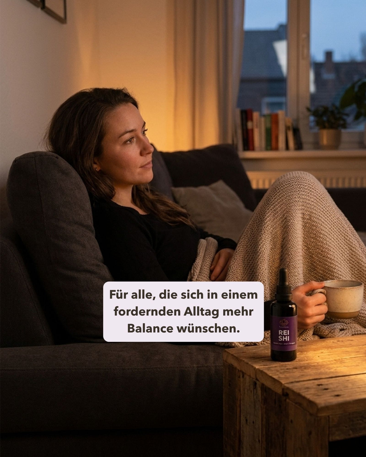 Frau auf Sofa mit Tasse und Reishi daneben. Textoverlay „Für alle, die sich in einem fordernden Alltag mehr Balance wünschen."