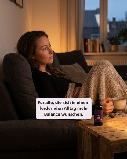 Frau auf Sofa mit Tasse und Reishi daneben. Textoverlay „Für alle, die sich in einem fordernden Alltag mehr Balance wünschen."